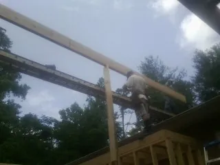 Carpenter setting a ridge beam over a new addition frame — Ice Dam Removal by Roofing Brothers in Franklin Lakes