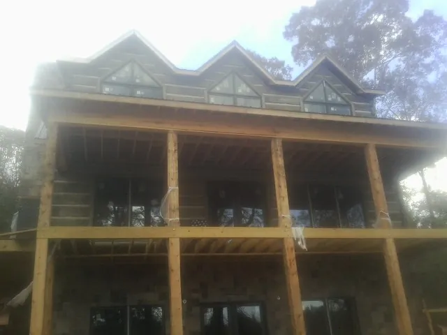 Dormers and porch framing on a large log home under construction — Roof Coating work by our crew in Franklin Lakes
