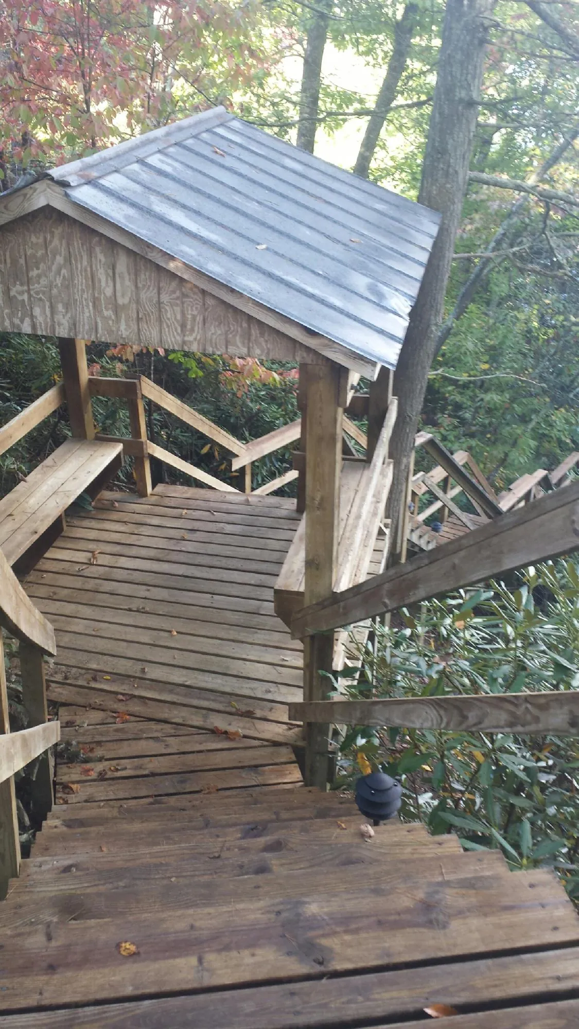 Metal roofed shelter over wooden steps on a wooded walkway — Skylight Repair & Installation work by our crew in Franklin Lakes