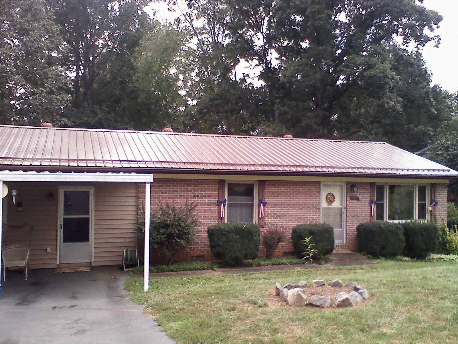 Bronze metal roof and carport on a brick ranch home — Roof Repair work by our crew in Franklin Lakes